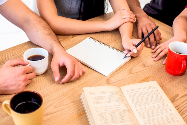 Groep die mensen samen met koffie op houten bureau bestuderen