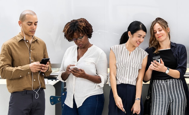 Groep diverse mensen die smartphones gebruiken