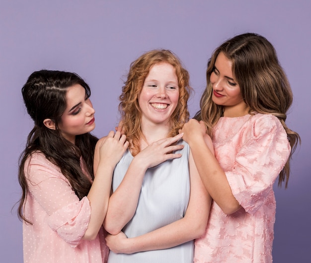 Groep en vrouwen die terwijl het houden van elkaar glimlachen stellen