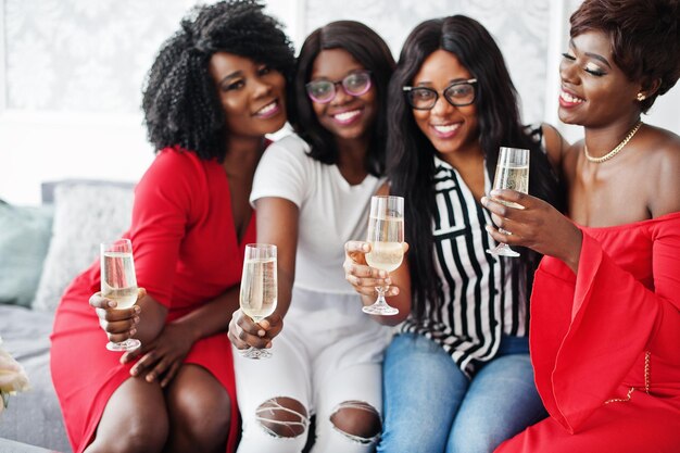 Groep feestende Afrikaanse meisjes rammelende glazen met mousserende wijn champagne