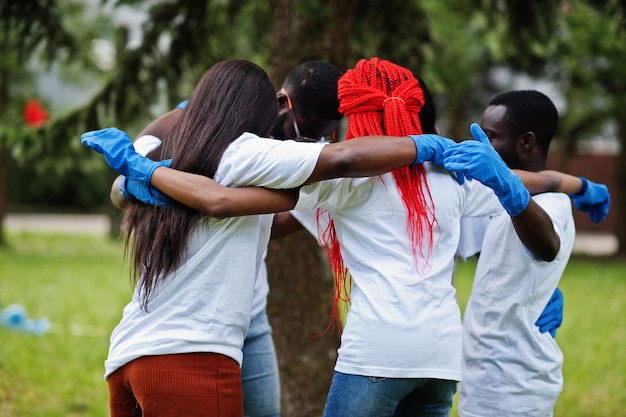 Groep gelukkige Afrikaanse vrijwilligers knuffels in park Afrika vrijwilligerswerk liefdadigheidsmensen en ecologie concept