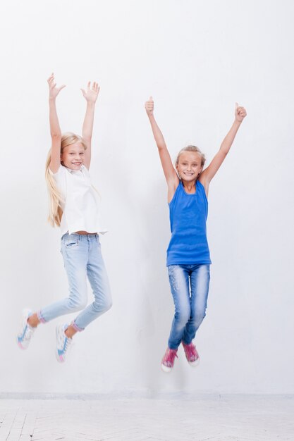 Groep gelukkige jonge meisjes die op wit springen