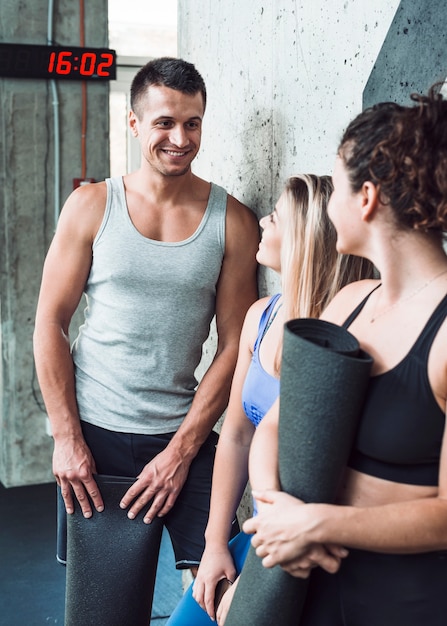 Groep gelukkige mensen met oefeningsmat in gymnastiek