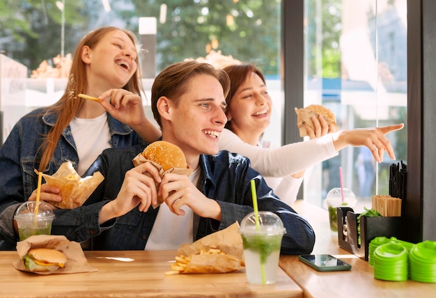 Groep gelukkige vrienden die hamburgers eten
