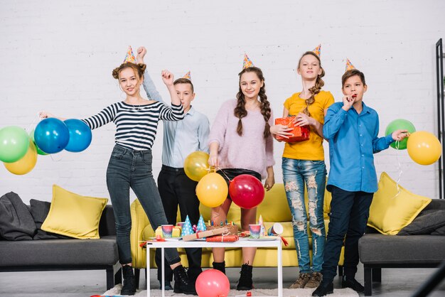 Groep gelukkige vrienden die in de verjaardagspartij genieten van