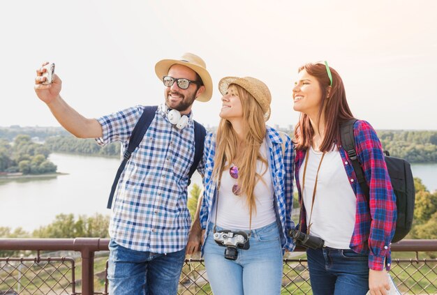 Groep gelukkige vrienden die selfie op cellphone in openlucht nemen