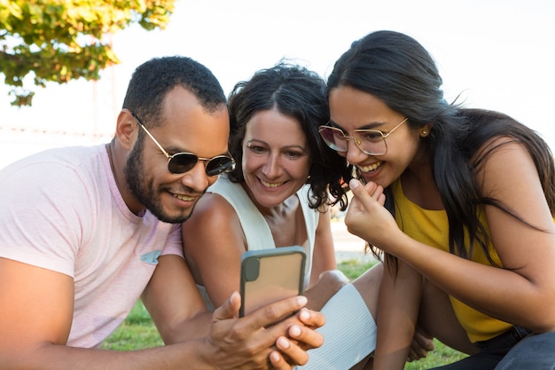 Groep gelukkige vrienden die smartphone gebruiken