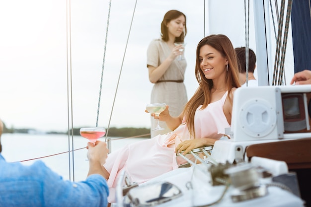 Groep gelukkige vrienden die wodkacocktails drinken op bootfeest buiten, zomer