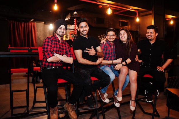 Groep Indiase vrienden die aan de loungebar zitten en plezier hebben en rusten