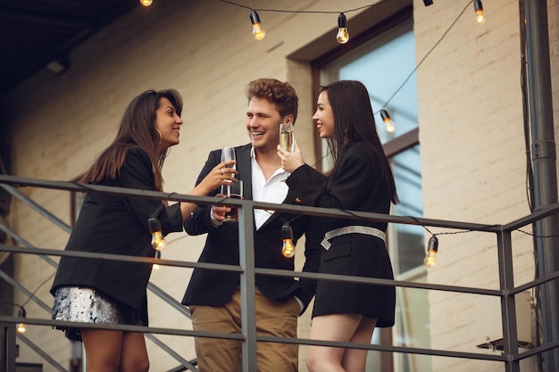 Groep jonge blanke mensen vieren, zien er gelukkig uit, hebben een bedrijfsfeest op kantoor of in de bar