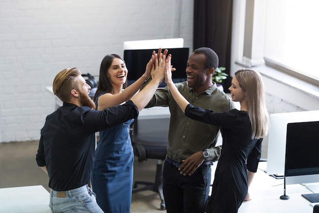 Groep jonge collega's geven elkaar een high five