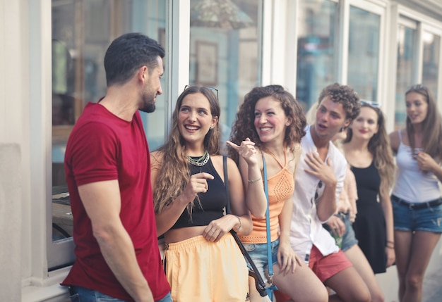 Gratis foto groep jonge mensen glimlachen terwijl ze in de straat staan