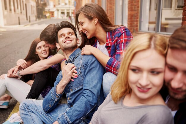 Groep jonge volwassenen die op de stoep zitten