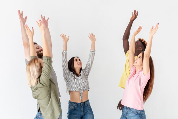 Groep jonge vrienden met hierboven opgeheven handen