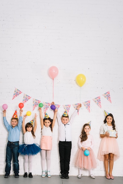 Groep kinderen die zich tegen muur bevinden die van de verjaardagspartij genieten