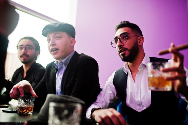 Groep knappe retro goedgeklede man gangsters tijd doorbrengen in club zitten en drinken whisky multi-etnische mannelijke vrijgezel maffia partij in restaurant