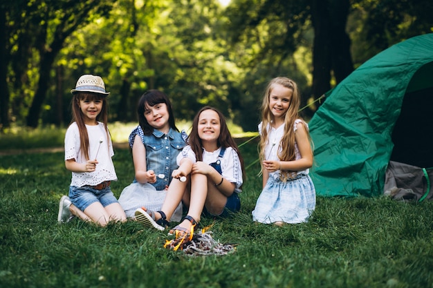 Groep meisjestoeristen door de tent in bos