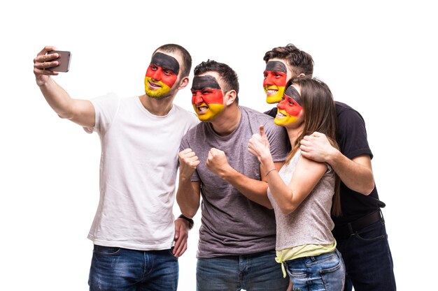 Groep mensen supporters fans van Duitse nationale teams met geschilderde vlag gezicht nemen sefie van telefoon. Fans van emoties.