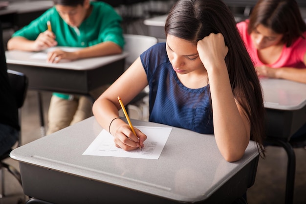 Groep middelbare scholieren die een test in een klaslokaal doen
