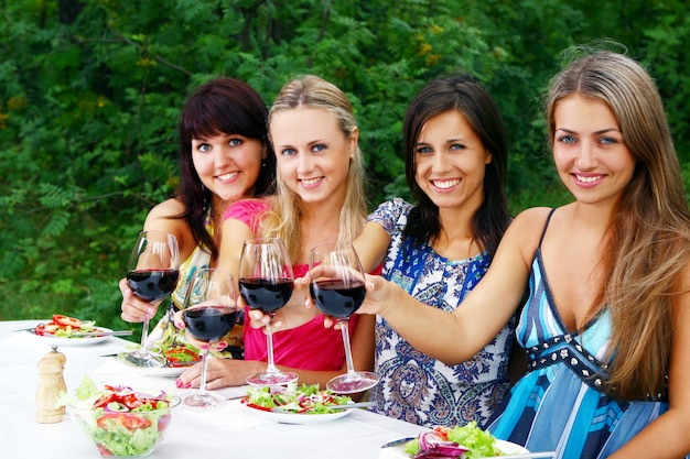 Groep mooie meisjes die wijn drinken