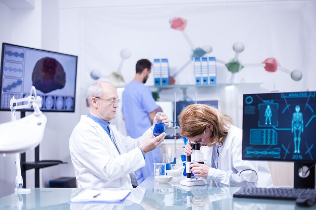 Groep onderzoekers in farmacologie in een ziekenhuislaboratorium. Moderne apparatuur in onderzoekslaboratorium.