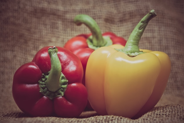 Gratis foto groep paprika's op rustieke jute achtergrond