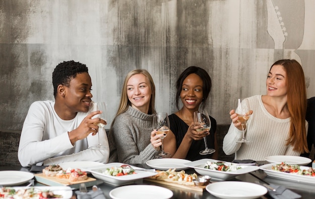 Groep positieve mensen die diner hebben samen