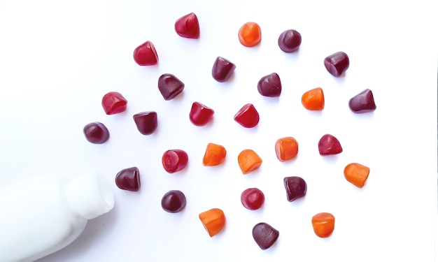 Groep rode, oranje en paarse multivitamine gummies met de fles geïsoleerd op een witte achtergrond. gezond levensstijlconcept.