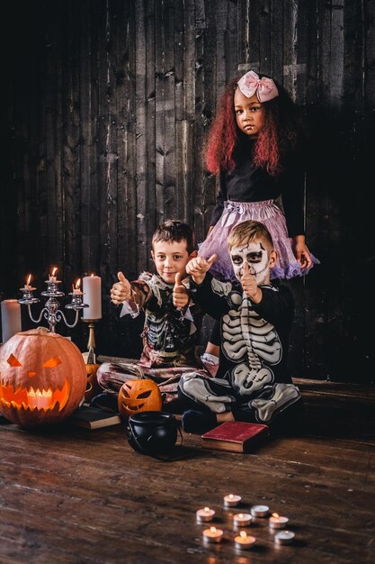 Groep schattige multiraciale kinderen in enge kostuums tijdens Halloween-feest in een oud huis. Halloween-concept.