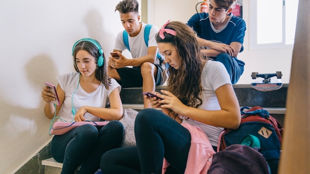 Groep schoolkinderen kijken naar smartphones