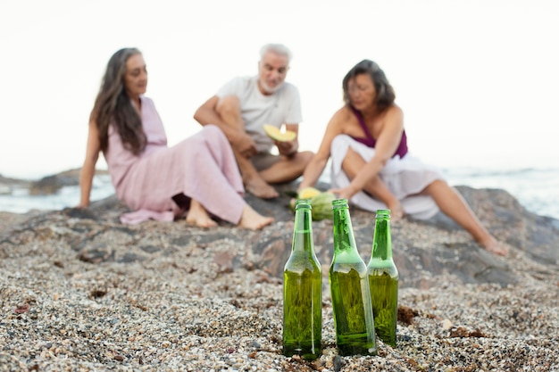 Groep senior vrienden met bier op het strand