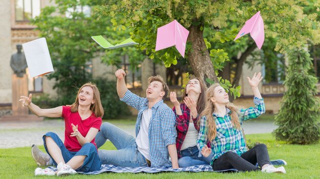 Groep studenten die boeken in de lucht werpen