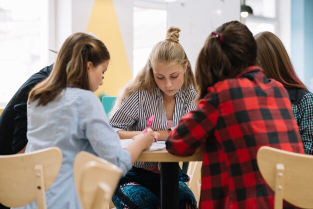 Groep studenten poseren aan tafel