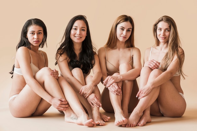 Groep van aantrekkelijke jonge vrouwen in ondergoed zitten in de studio