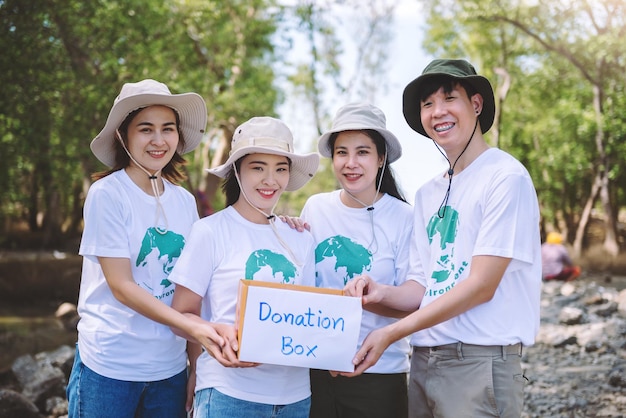Groep van aziatische diverse mensen die vrijwilligerswerk doen met een donatiebox voor fondsenwerving voor een noodsituatie, zoals hulp aan slachtoffers van overstromingen in Oekraïne, voedsel voor kinderen, liefdadigheidsevenement Conceptuele vrijwilligerswerk