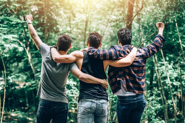 Groep van jonge Man steek Hand omhoog betekenis tot succesvol en voltooid avontuur in wandelen Camping reis buiten in het bos reizen in zomervakantie Concept