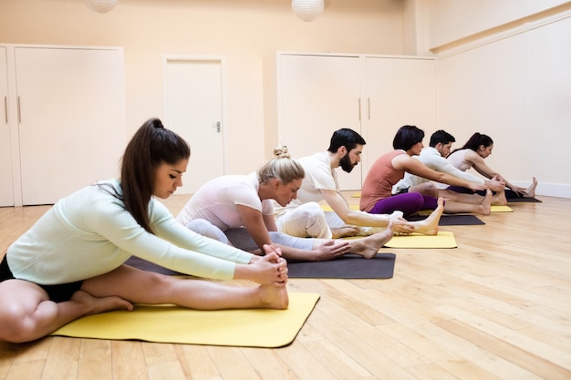 Groep van mensen die het uitvoeren stretching oefening op oefening mat