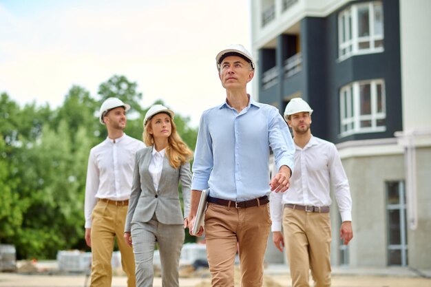 Groep van vier mensen die over een nieuw bouwterrein lopen