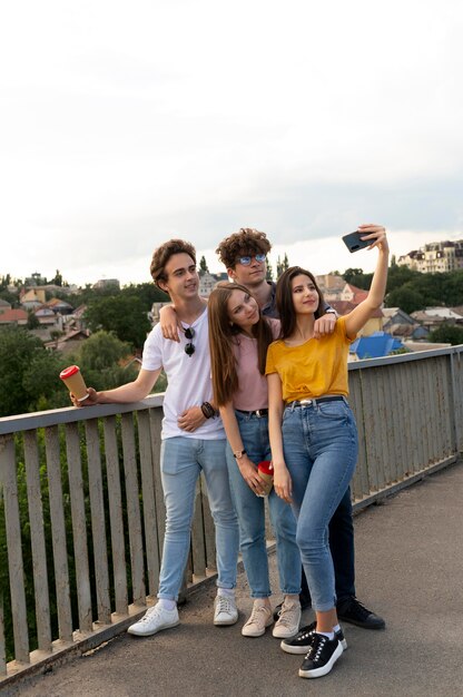 Groep van vier vrienden die samen buiten tijd doorbrengen en selfie maken