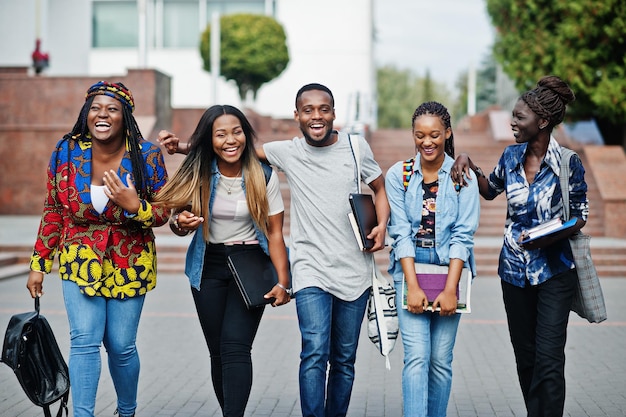 Groep van vijf Afrikaanse studenten die samen tijd doorbrengen op de campus van de universiteitswerf Zwarte afro-vrienden die onderwijsthema studeren