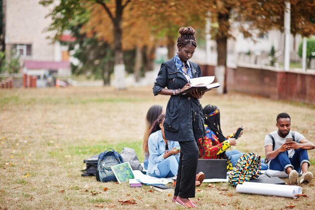 Groep van vijf Afrikaanse studenten die samen tijd doorbrengen op de campus van de universiteitswerf Zwarte afro-vrienden die onderwijsthema studeren