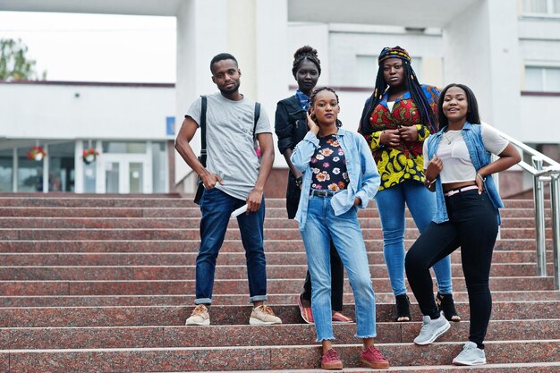 Groep van vijf Afrikaanse studenten die samen tijd doorbrengen op de campus van de universiteitswerf Zwarte afro-vrienden die onderwijsthema studeren