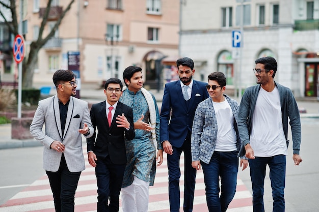 Groep van zes zuid-aziatische indiaan mans in traditionele vrijetijds- en zakelijke kleding die samen op zebrapad lopen