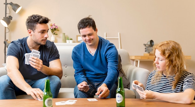 Groep vrienden die bier hebben en speelkaarten thuis