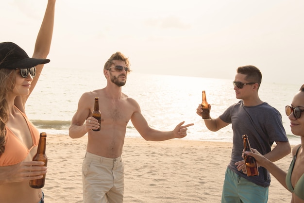 Groep vrienden die bij het strand drinken