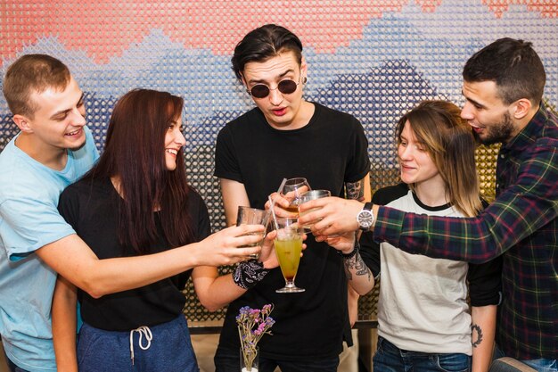 Groep vrienden die cocktails roosteren