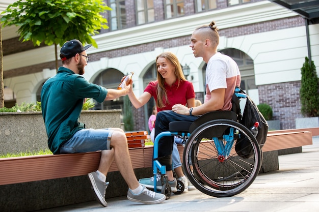 Groep vrienden die een wandeling op straat van de stad in zomerdag maken