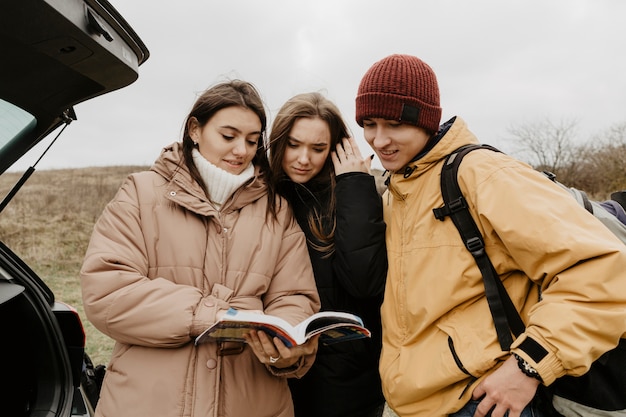 Gratis foto groep vrienden die gidsboek raadplegen