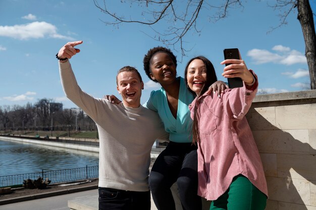 Groep vrienden die het opheffen van de beperkingen van gezichtsmaskers vieren door samen buitenshuis een selfie te maken
