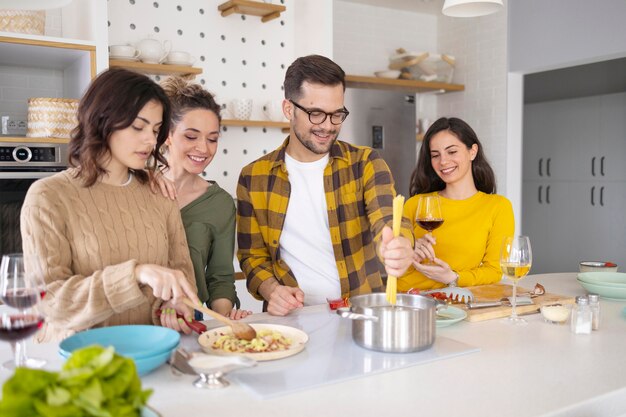 Groep vrienden die maaltijd in de keuken bereiden